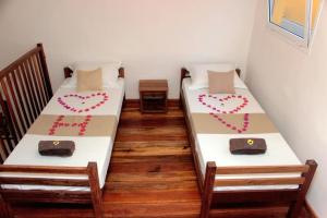 twee bedden in een kamer met harten erop geschilderd bij Hotel Vanivola in Sainte Marie