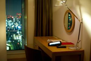a desk with a lamp and a book on it at Park Hotel Tokyo in Tokyo