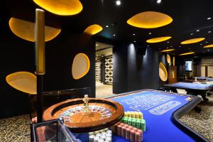 una sala de juegos con una ruleta y dos mesas en Porto Carras Meliton en Neos Marmaras