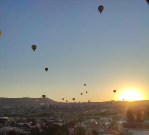 um grupo de balões de ar quente no céu ao pôr do sol em Balloon View Hotel em Goreme