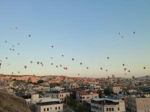 un grupo de globos de aire caliente volando sobre una ciudad en Balloon View Hotel en Goreme