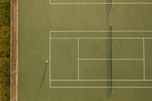 a tennis court with a tennis racket and a tennis ball at Porto Carras Meliton in Neos Marmaras