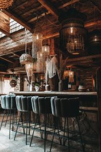 a bar with chairs and chandeliers in a room at Jufenalm BOHO Hotel & Restaurant in Maria Alm am Steinernen Meer