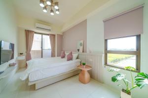 a white bedroom with a bed and a window at Rice mansion in Wujie