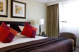 een hotelkamer met een bed met rode kussens bij Warwick Paris (Former Warwick Champs-Elysees) in Parijs