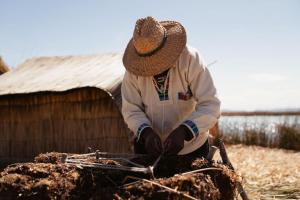 a man in a straw hat sitting on a stick at Titilaka - Relais & Châteaux in Tililaca