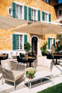 un patio con sillas, mesas y una sombrilla en Borgo il Mezzanino, en Saló