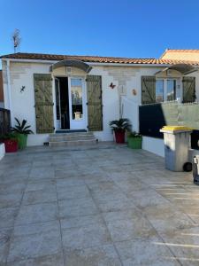 a white house with a patio in front of it at Villa Cosy de plain pied - Marseillan in Marseillan