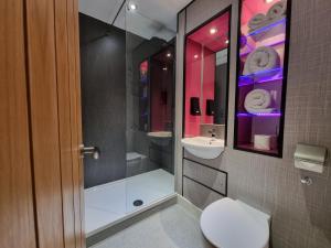 a bathroom with a shower and a toilet and a sink at Escape Hotel in Barrow in Furness