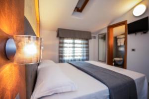 a bedroom with a bed and a lamp on a wall at Hotel Gabbiano in Rimini