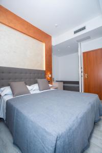 a bedroom with a large bed with a blue blanket at Hotel Gabbiano in Rimini