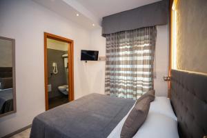 a bedroom with a bed and a mirror and a bathroom at Hotel Gabbiano in Rimini