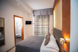 a bedroom with a bed and a bathroom with a toilet at Hotel Gabbiano in Rimini