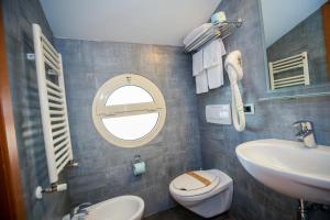 a bathroom with a sink and a toilet and a mirror at Hotel Gabbiano in Rimini