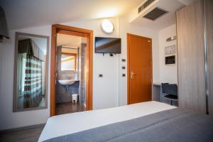 a bedroom with a bed and a bathroom with a sink at Hotel Gabbiano in Rimini