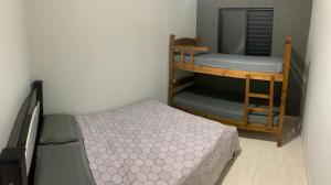 een kleine slaapkamer met een stapelbed en een bed en een stapelbed bij Casa de Temporada Dona Santa in Olímpia