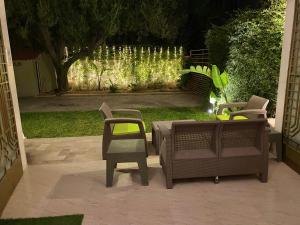 eine Terrasse mit 2 Stühlen, einem Tisch und Lampen in der Unterkunft Elegant Relaxing Oasis in the Heart of Sfax in Sfax