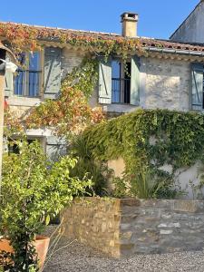una casa con hiedra creciendo a su lado en Le Domaine de La Tuilerie - Gite de charme en bord de riviere avec piscine, en Serviès-en-Val