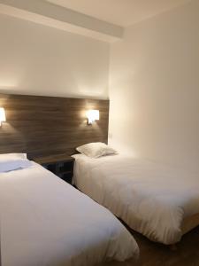 two beds in a hotel room with white sheets at Logis Hotel des Portes de Meuse in Pagny-sur-Meuse
