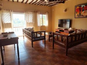 a living room with two beds and a flat screen tv at Galawa Beach Apartments in Diani Beach