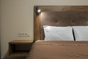 a bedroom with a bed with a wooden headboard and pillows at Borys Hotel Boryspil Airport in Boryspil