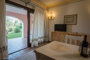 comedor con mesa y puerta corredera de cristal en Il Giardino degli Oleandri en Liscia di Vacca