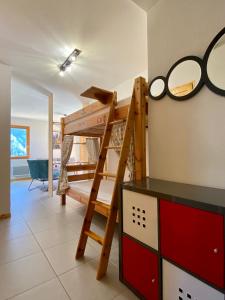 a room with a bunk bed and a ladder at Le Nid in Vaujany