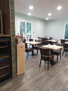a dining room with tables and chairs and a fireplace at Logis Hotel des Portes de Meuse in Pagny-sur-Meuse