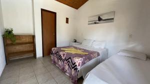 En eller flere senge i et værelse på Pousada Caravelas