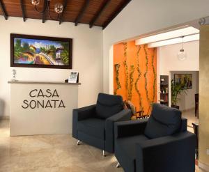 a salon with two chairs and a sign on the wall at Hotel Casa Sonata in Medellín