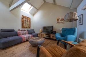 a living room with blue couches and a tv at TUUS in Dishoek in Dishoek