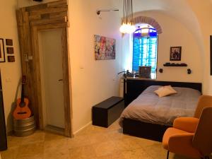 a bedroom with a bed and a guitar in a room at REENE Boutique Suites The Milano Suite in Jerusalem
