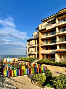 a building with a colorful fence next to the beach at Obzor Beach Resort in Obzor