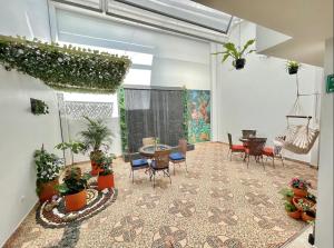 a room with a table and chairs and plants at Hotel Casa Sonata in Medellín