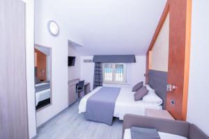 a hotel room with a bed and a window at Hotel Gabbiano in Rimini