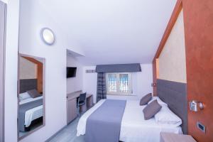 a hotel room with a bed and a mirror at Hotel Gabbiano in Rimini