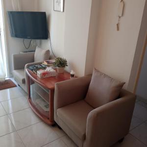 a living room with a couch and a table with a tv at Makenzy 12 in Larnaka