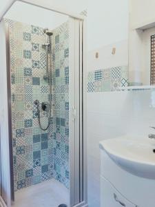 y baño con ducha y lavamanos. en Isola Verde Guest House, en Fiumicino