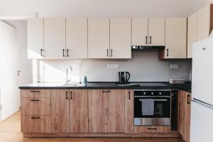 a kitchen with white cabinets and a sink and a stove at Apartmán Efka in Deštné v Orlických horách