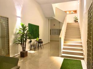 a staircase in a room with a table and a plant at Elegant Relaxing Oasis in the Heart of Sfax in Sfax