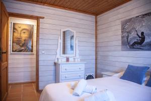 タリファにあるRural Tarifa Beach Las Cabañasのベッドルーム1室(ベッド1台付)が備わります。壁には絵画が飾られています。