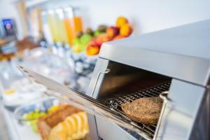 a grill with a hamburger and bread and fruit at Hotel Gabbiano in Rimini