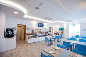 a dining room with tables and blue chairs at Hotel Gabbiano in Rimini