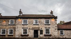 an old stone building with a sign on it at Bay Horse Inn Goldsborough in Knaresborough