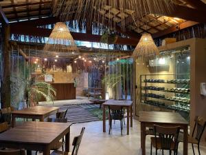 a restaurant with tables and chairs and wine racks at Naim Milagres in São Miguel dos Milagres