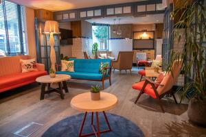a lobby with couches and chairs and tables at The Corner London City in London