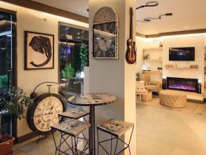 a room with a clock and a table and chairs at L'opera Deluxe Hotel in Akçay