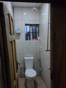 a bathroom with a toilet and a window at The Edgewood Manor, Entire Service apartment with 24 hours power in Akure