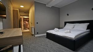 een slaapkamer met een bed met witte lakens erop bij Hotel Made in Napoli by Siervo Międzybórz in Neumittelwalde