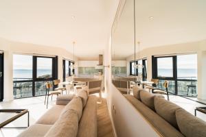 a living room with a large couch and windows at Westcliff Penthouse in Bournemouth